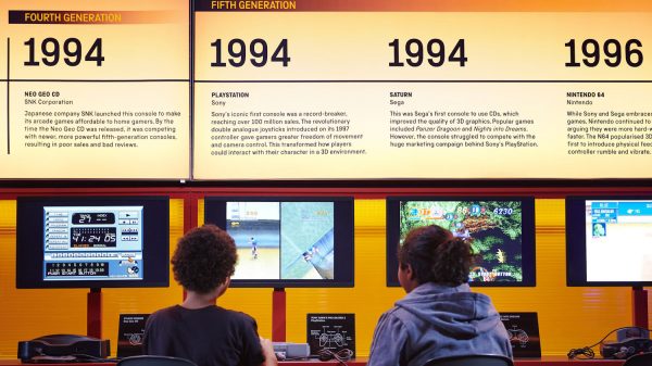 Kids sit in front of the timeline of video games from the Science Museum's Power Up exhibit